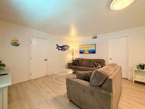 Ein Wohnzimmer mit einer Couch, einem Couchtisch und einem Gemälde an der Wand.