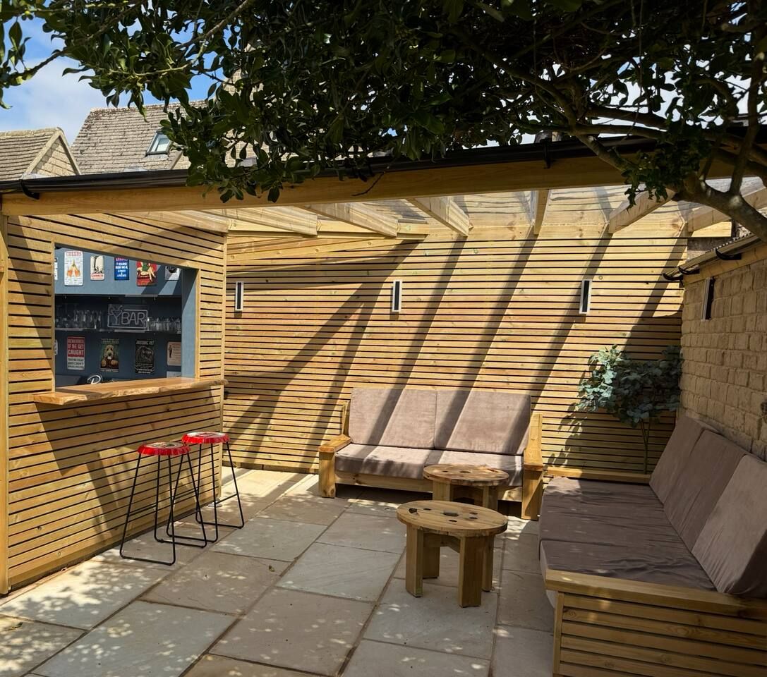 A wooden deck with a bar area, seating, and a small table.