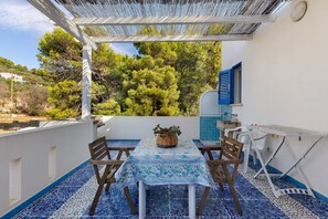 A patio with a table and chairs, a small sink, and a window overlooking trees. - Villa Il Fior D'Oro with Private Terrace, Wi-Fi, and Air Conditioning (Alessano)