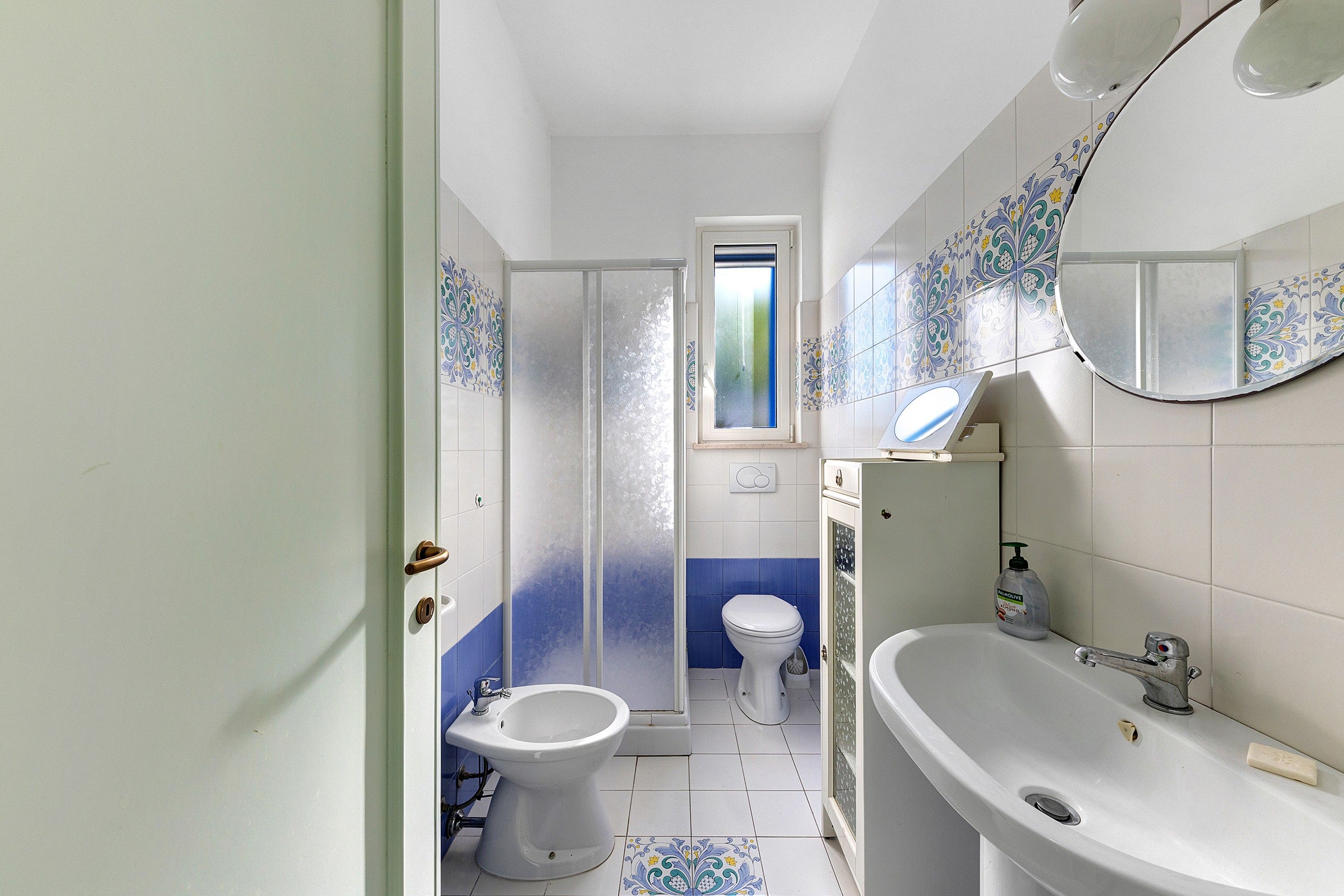 A bathroom with a bidet, toilet, and a large sink.