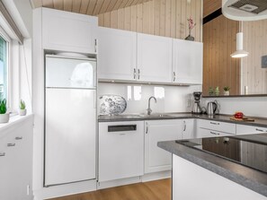 A modern kitchen with white cabinetry, a built-in oven, and a stainless steel sink. - "Clarice" - 250m to the fjord by Interhome (Vinderup)