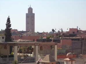 A view of a cityscape with a prominent tower and surrounding buildings. - Dar moulay Ali (MARRAKECH)
