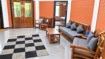 Un vestíbulo con alfombra a cuadros, muebles de madera y un reloj en la pared.