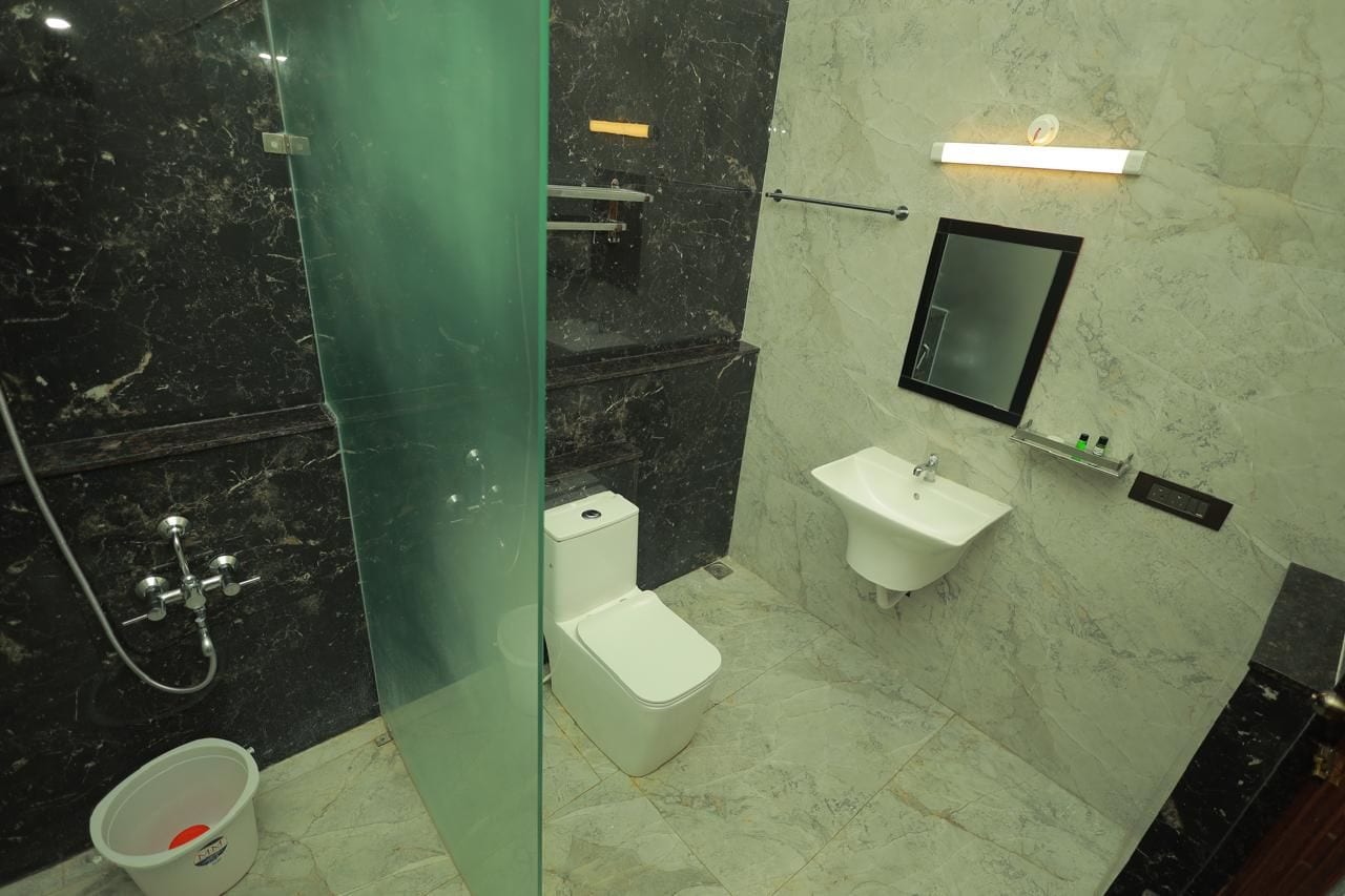 Ein Badezimmer mit Duschkabine, Toilette, Waschbecken und Spiegel.