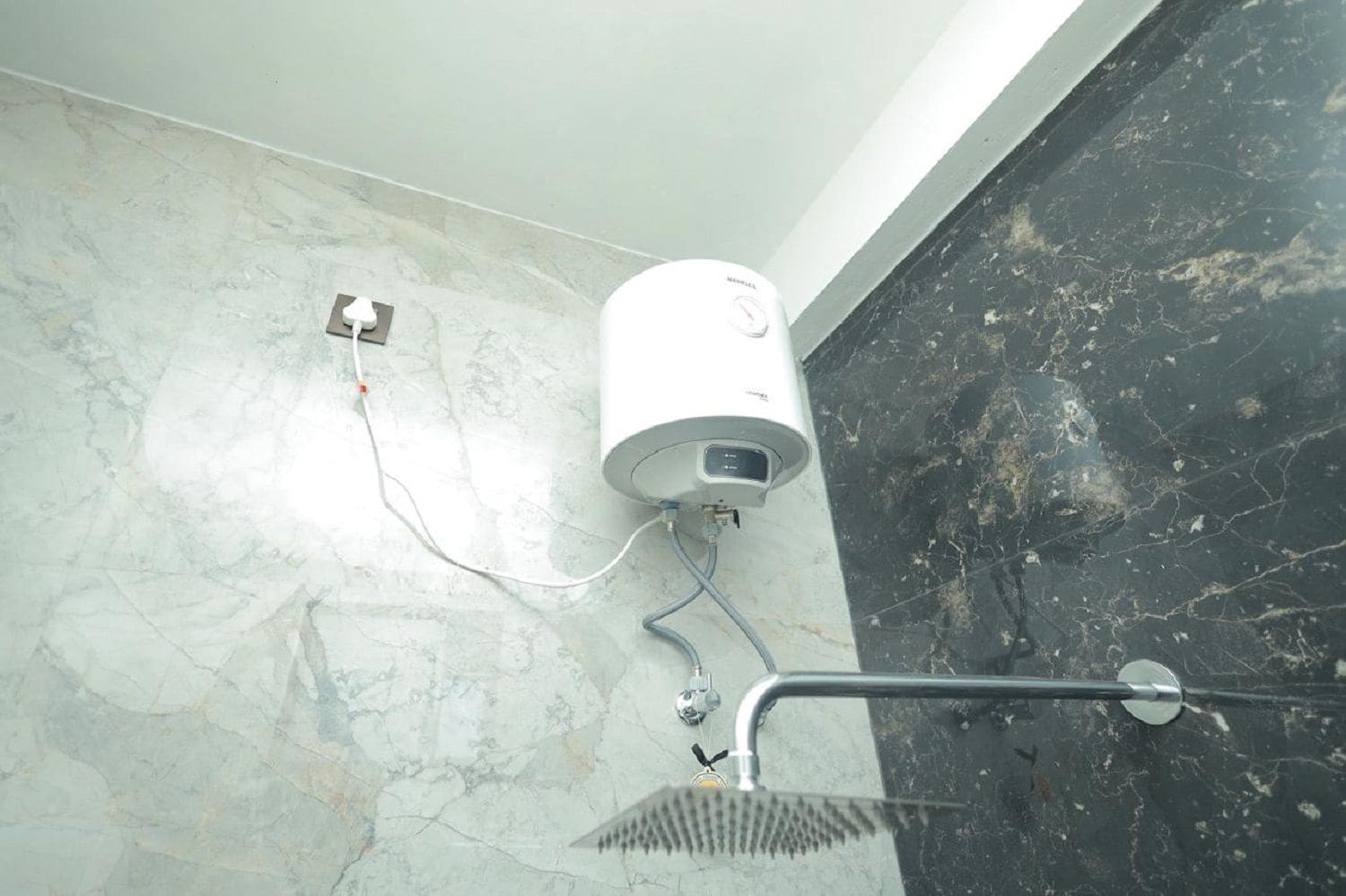 A bathroom with a shower, a white water heater mounted on the wall, and a marble floor.