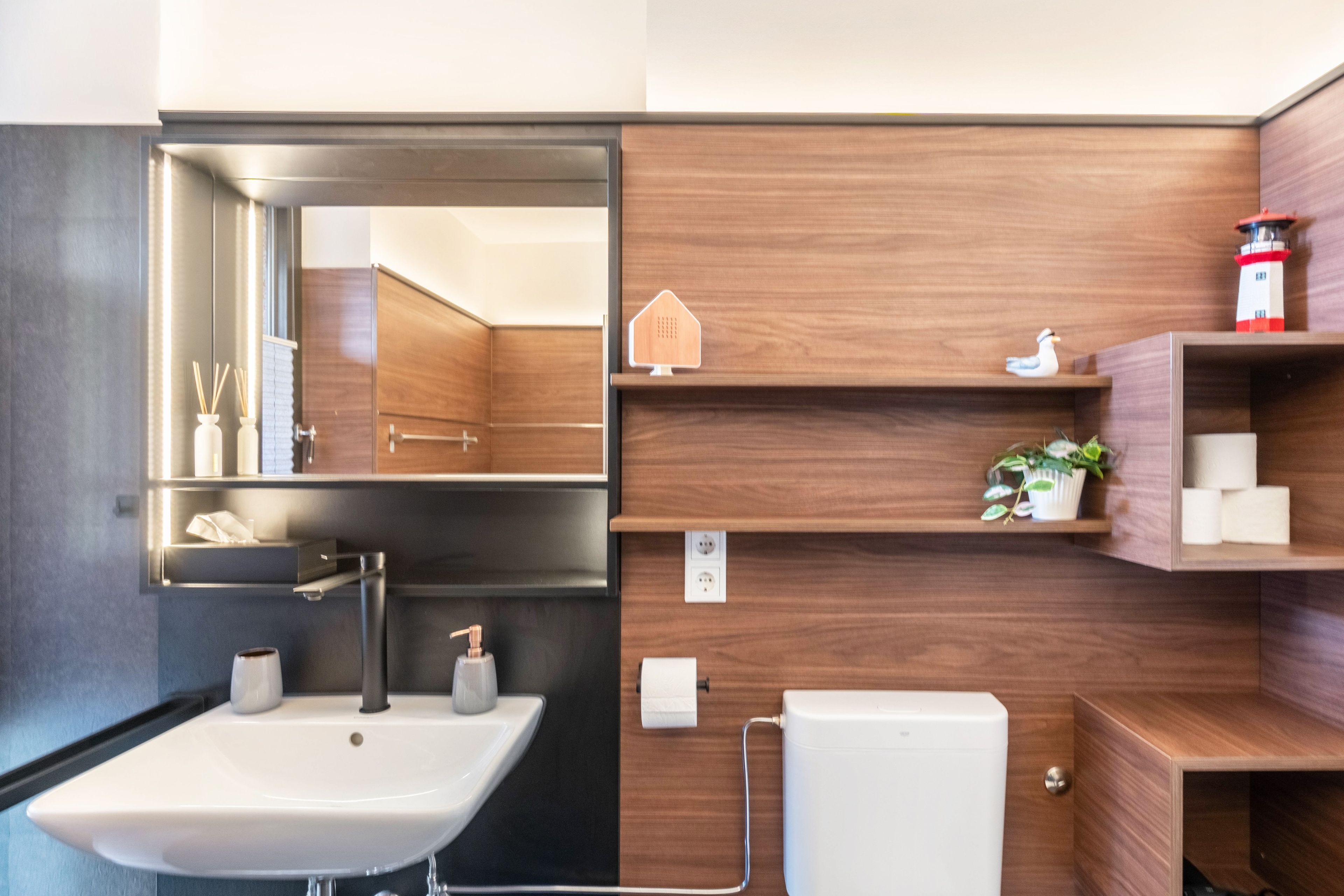 A bathroom with a sink, mirror, and wooden shelves.