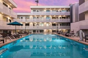A hotel with a swimming pool, multiple balconies, and lounge chairs. - Welcome to your Nashville getaway! This modern 1-bedroom, 1-bath condo is located in the heart of Downtown, just steps from Broadway’s live music, incredible dining, and local attractions. Perfect for couples, solo travelers, or business guests. (Nashville)