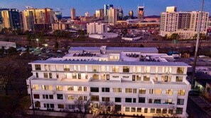 A multi-story hotel with a flat roof and uniform window design, surrounded by a cityscape at dusk. - Welcome to your Nashville getaway! This modern 1-bedroom, 1-bath condo is located in the heart of Downtown, just steps from Broadway’s live music, incredible dining, and local attractions. Perfect for couples, solo travelers, or business guests. (Nashville)