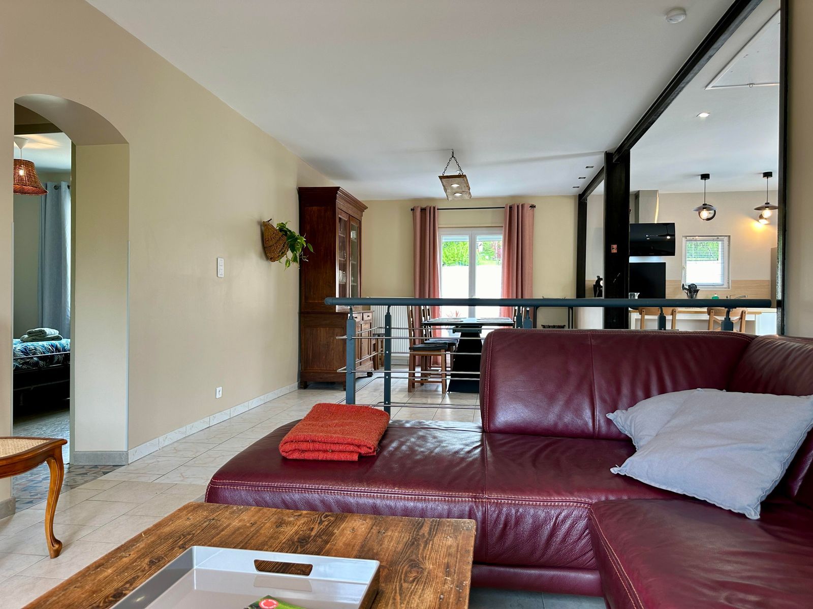 A living room with a leather sofa, a wooden coffee table, and a kitchen in the background.