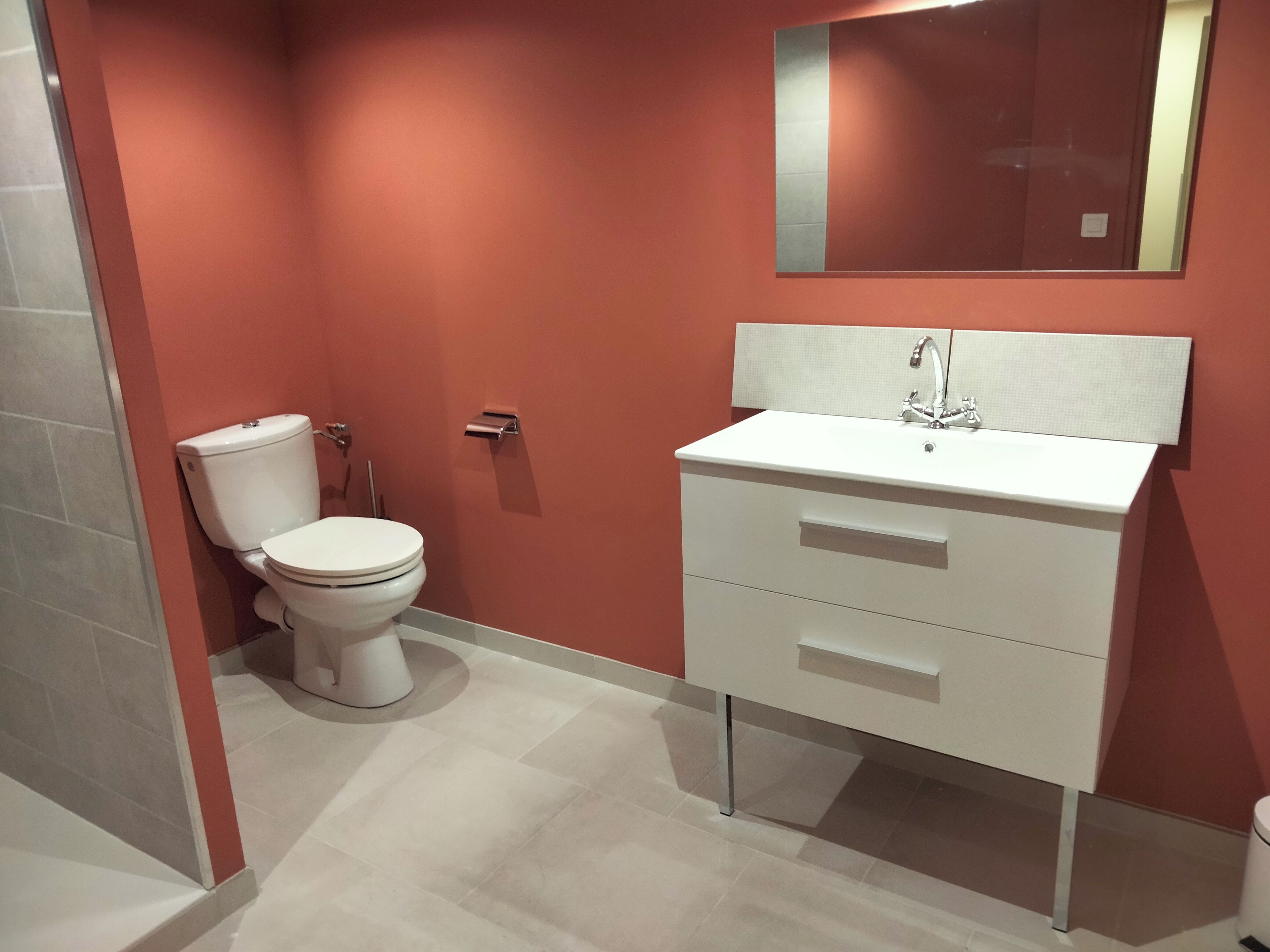 Un baño con inodoro, lavabo y espejo.
