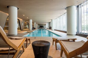 Zona de piscina amb gandules i una columna central.