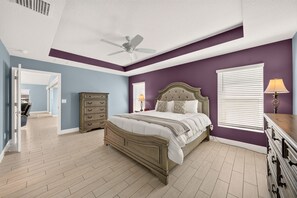 Ein Schlafzimmer mit Bett, Schminktisch und Deckenventilator.