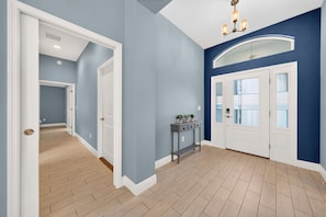 Ein Flur mit Holzdielen, weißen Türen und einer blauen Wand.