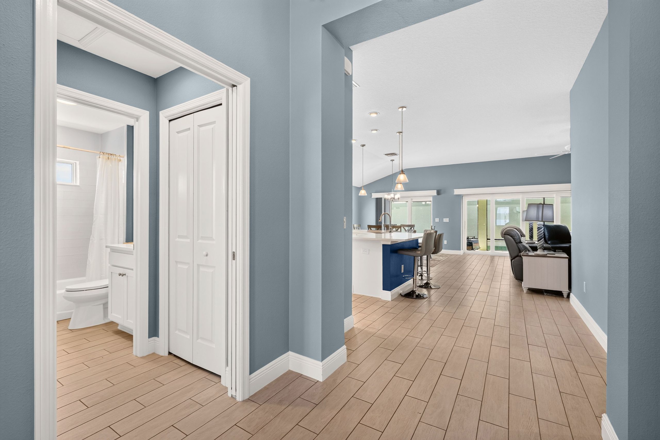 A spacious bathroom with a toilet, shower, and a white door.