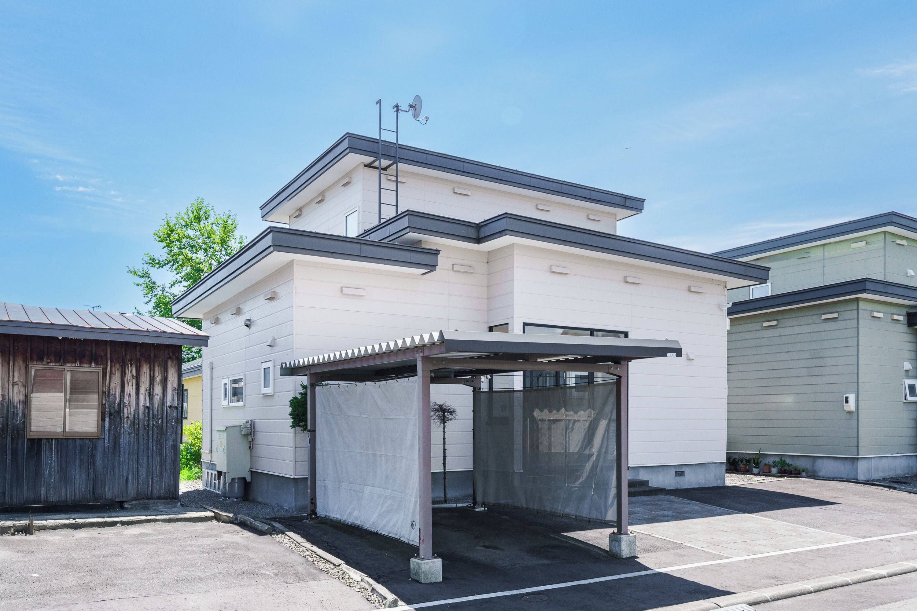 A modern building with a covered entrance and a satellite dish.