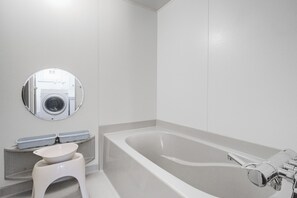 Un baño moderno con bañera, inodoro y espejo.