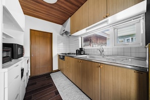 Una cocina moderna con armarios de madera, encimera de acero inoxidable y horno empotrado.