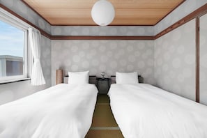Habitación con cama doble, techo de madera, mesita de noche y lámpara.