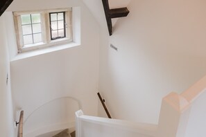 A staircase with a white handrail and a window above it. - Little Hale Cottage (Painswick)