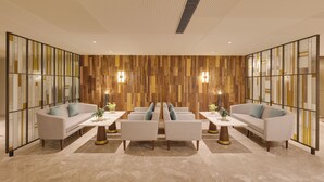 A modern living room with a patterned wall, two sofas, a coffee table, and decorative lighting. - Lemon Tree Premier, Jabalpur (Jabalpur)