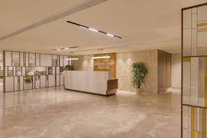 A modern reception area with a marble reception desk, a potted plant, and a partition with a view of the seating area. - Lemon Tree Premier, Jabalpur (Jabalpur)