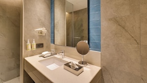 A modern bathroom with a large mirror, a sink, and a shower area. - Lemon Tree Premier, Jabalpur (Jabalpur)