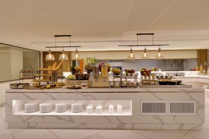 A modern breakfast buffet with various food items and a selection of plates and bowls. - Lemon Tree Premier, Jabalpur (Jabalpur)