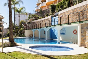 A swimming pool with a stone wall, a lifebuoy, and a staircase leading to an upper level. - Luxury Penthouse | Private Terrace & Sea Views (Marbella)