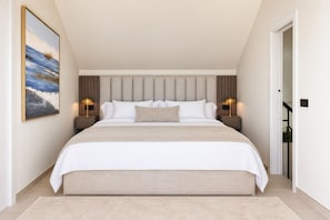 A modern bedroom with a large bed, two bedside tables with lamps, a headboard, and a painting on the wall. - Luxury Penthouse | Private Terrace & Sea Views (Marbella)
