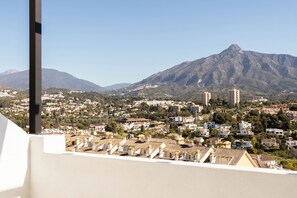 A residential area with a mountain in the background, houses with tiled roofs, and a clear sky. - Luxury Penthouse | Private Terrace & Sea Views (Marbella)