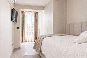 A modern bedroom with a large bed, a television mounted on the wall, and a window with curtains. - Luxury Penthouse | Private Terrace & Sea Views (Marbella)