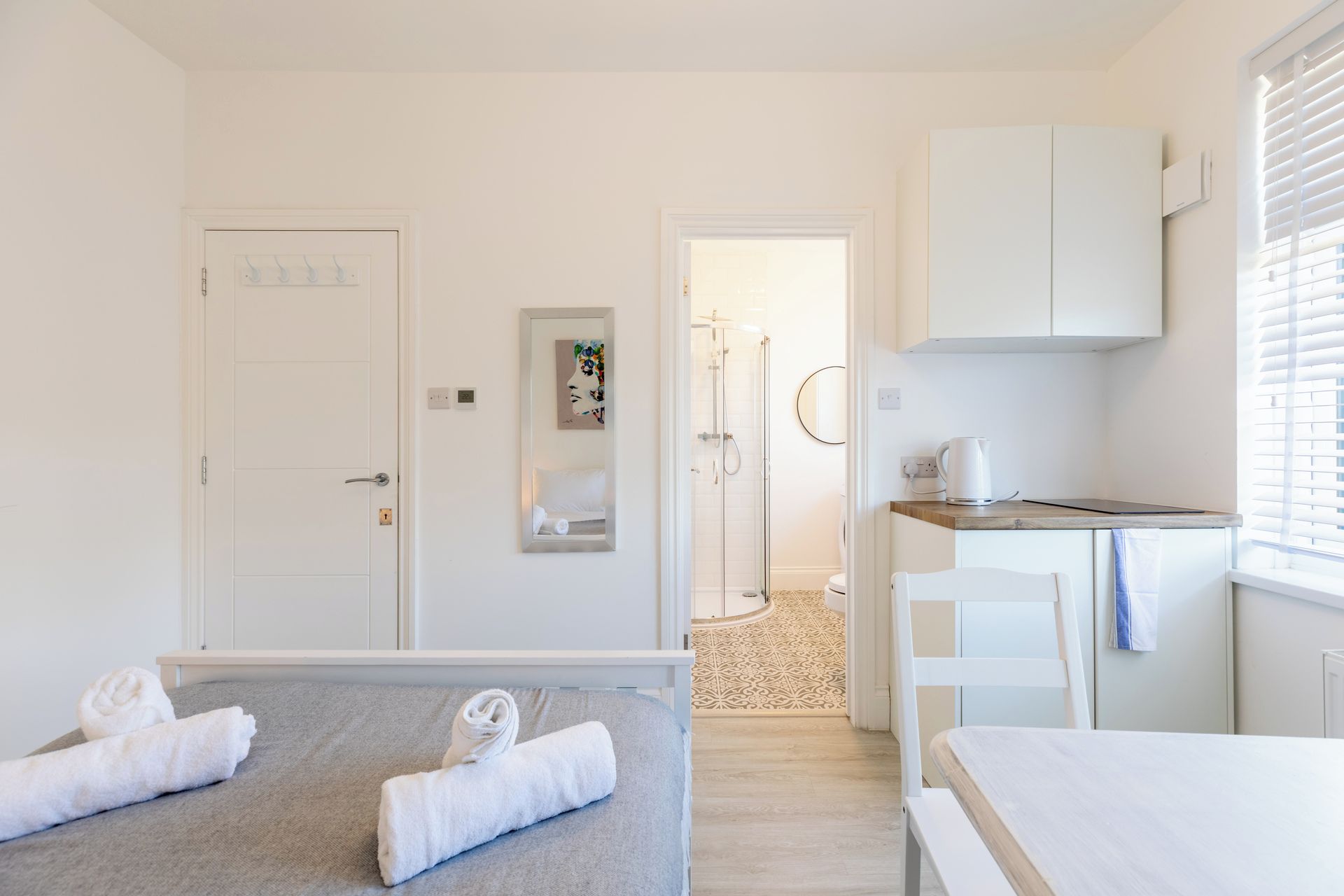 Une chambre d’hôtel comprenant un lit, une salle de bain, une kitchenette et une douche.