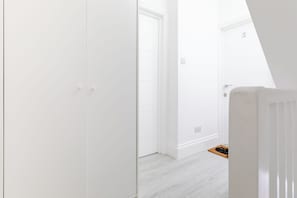 A white interior with a door leading to another room, a visible electrical outlet, and a number '3' on the wall. - Bright First Floor Studio with Private Shower Room (Greater London)