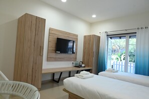A hotel room with a bed, a desk, a TV, and a window with curtains. - Kahuna Resorts - Find your Shore (Vengurla)