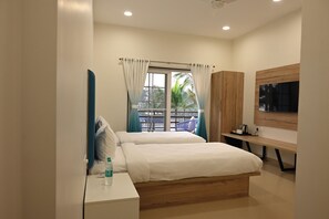Een moderne slaapkamer met een bed, nachtkastje en een aan de muur bevestigde televisie.