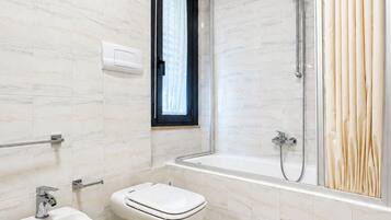 Ein modernes Badezimmer mit integriertem Bidet, Toilette und einer Duschkabine.