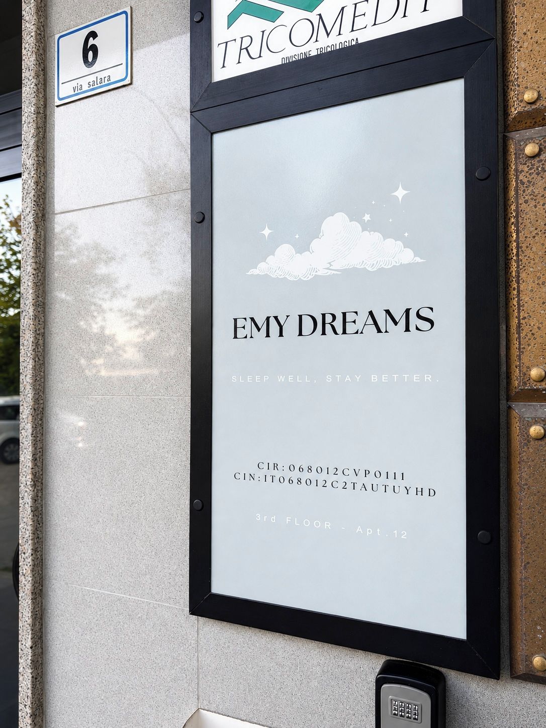 Une plaque encadrée portant l’inscription « EMY DREAMS » et le slogan « DORMEZ BIEN, VIVEZ MIEUX ». Elle comprend également un numéro de téléphone et une adresse.