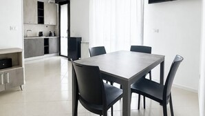 Una cocina moderna con armarios grises, encimera negra y horno empotrado.