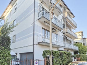 A multi-story residential building with balconies, a gated entrance, and a clear sky. - defaultName (Vicenza)