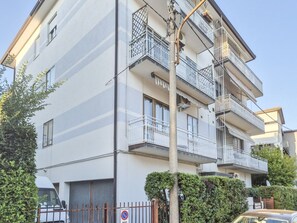 A multi-story residential building with balconies, a gated entrance, and a clear sky. - defaultName (Vicenza)