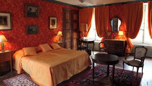 A bedroom with a bed, a desk, a chair, a dresser, and a mirror. - Château D'Island: Delphine Suite (Island)