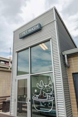A pet wash facility with a large glass window and a metal exterior. - Gorgeous 2 Bedroom unit with a Pool (Columbus)