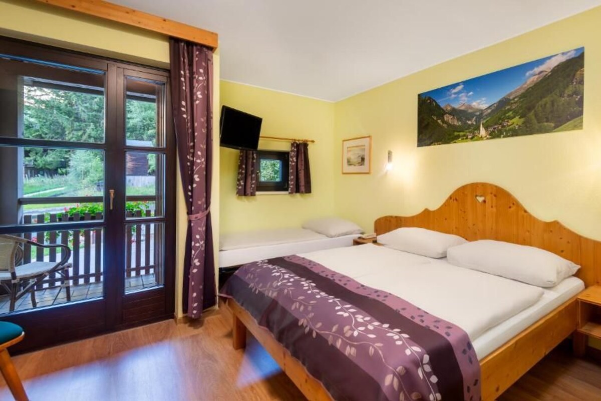 Une chambre d’hôtel avec un lit, un bureau et une vue sur l’extérieur.