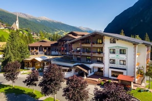 Un hôtel à étages, doté de balcons et situé dans un cadre montagneux.