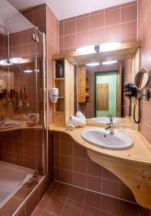 Une salle de bain avec une douche à parois de verre, un meuble-lavabo en bois et un miroir.