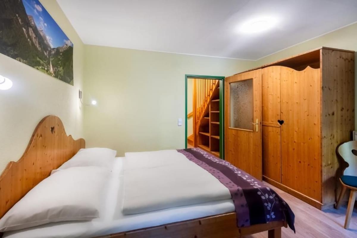 Une chambre à coucher avec un lit, une armoire et une chaise.