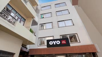 A multi-story building with a sign for 'OYO Hotel Vintage' indicating a hotel establishment.