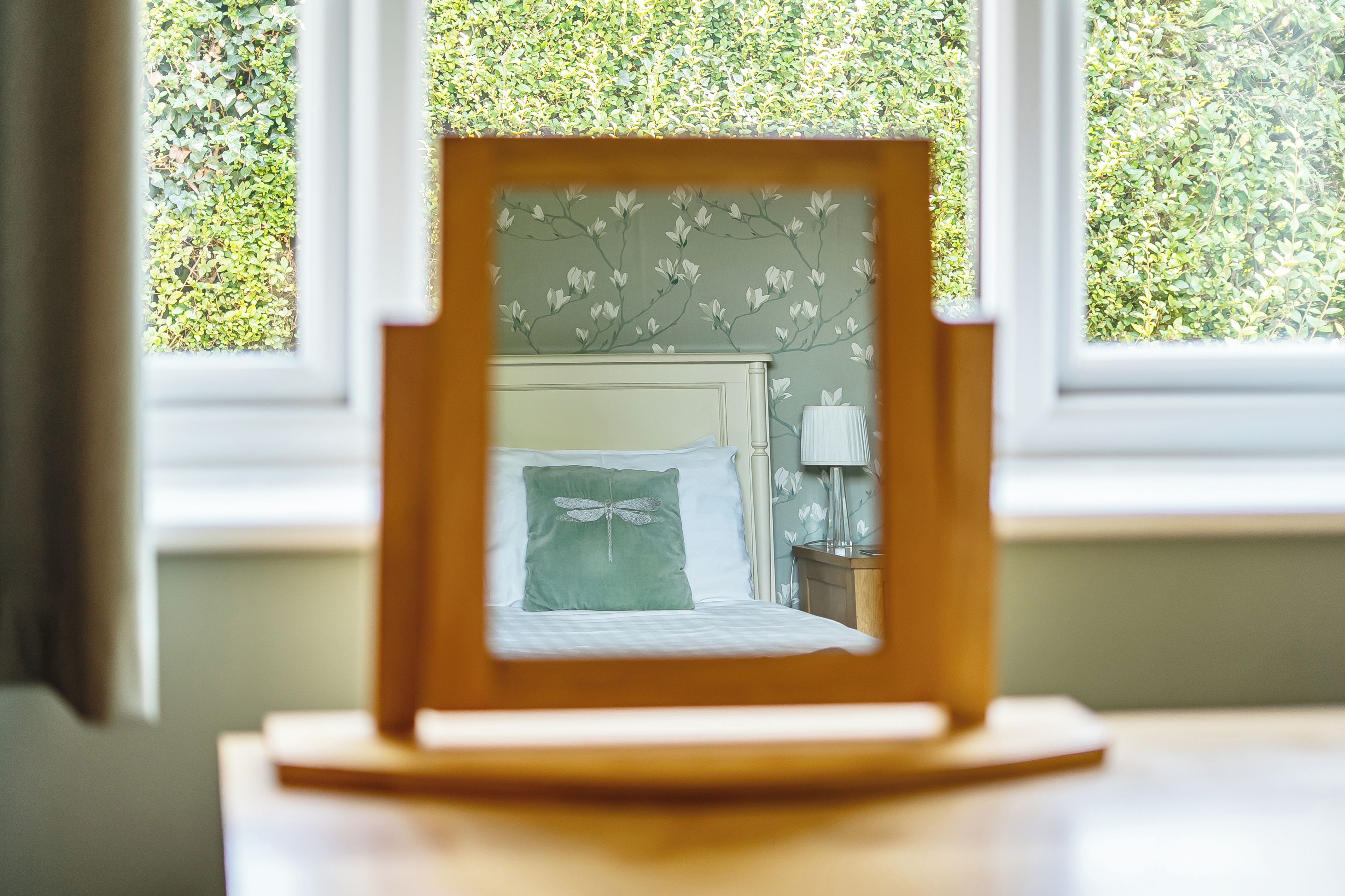 A framed picture with a bed and a nightstand in the background.
