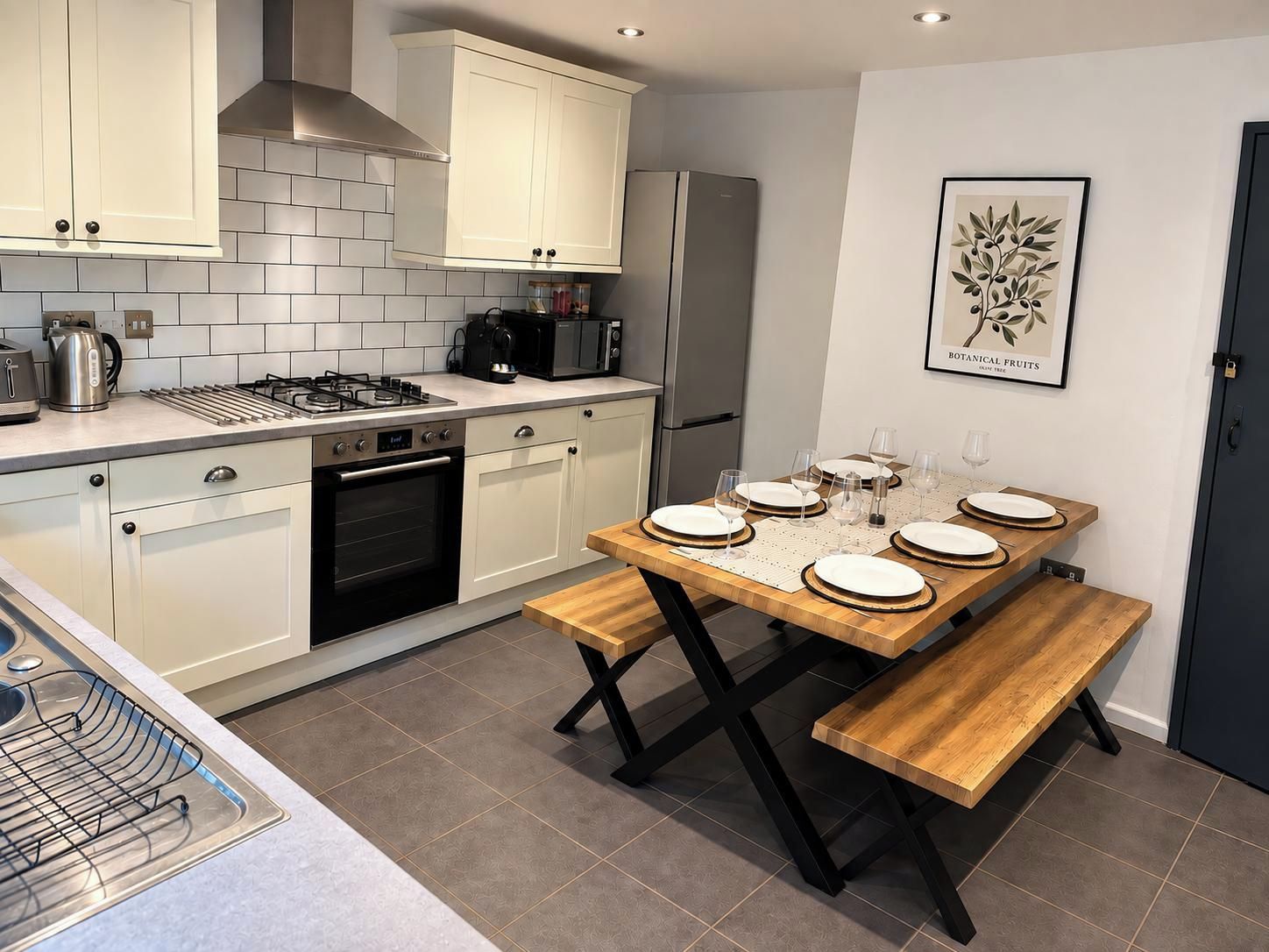 A modern kitchen with white cabinetry, a gas stove, a microwave, and a refrigerator.