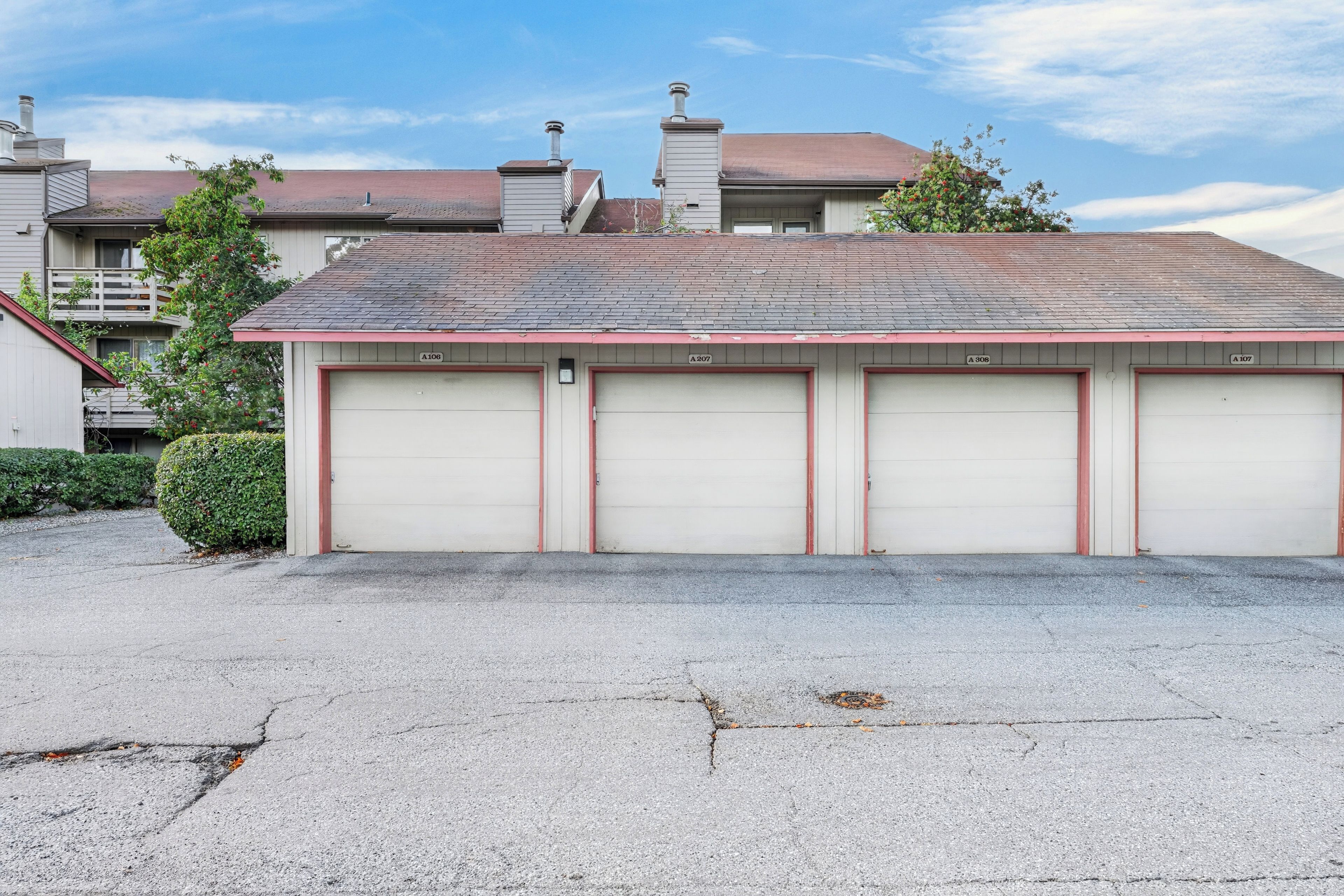 A two-story building with a garage featuring four doors.